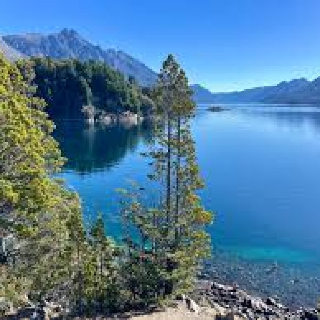 Sunset over a lake surrounded by mountains.